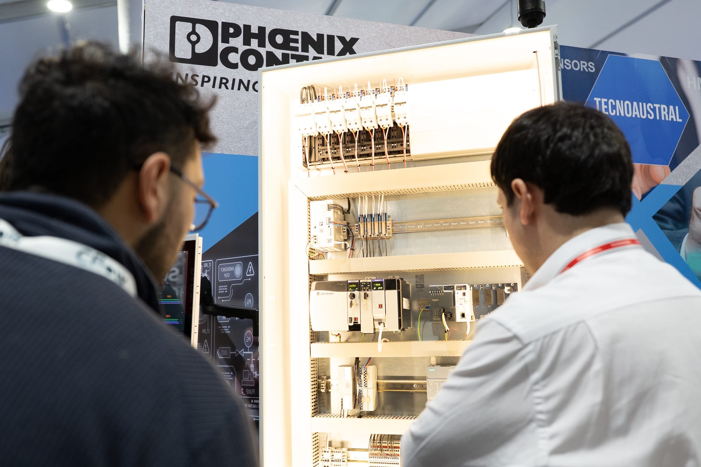 Visitors looking at a control panel with Phoenix Contact technology
